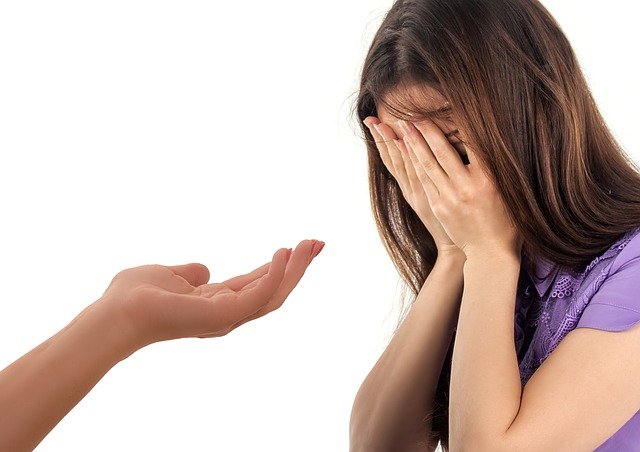 A  helping hand pointing towards a sad girl